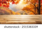 Empty wood table top and blurred autumn tree and red leaf background - can used for display or montage your products