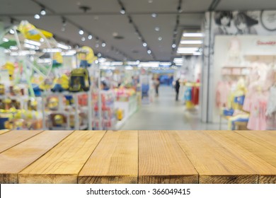 Empty Wood Table Top With Blurred Background Of  Toys Department Store,Natural Bokeh Shopping Mall Toy Store,vintage Color.- Can Be Used For Montage Or Display Your Products