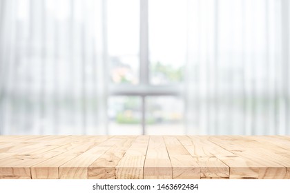 Empty of wood table top on blur of white curtain with window view background.For montage product display or design key visual layout