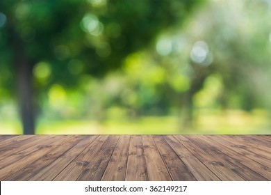 Empty wood table top on forest background. can montage or display your products