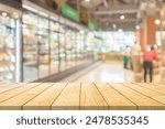 Empty wood table top with supermarket grocery store aisle and shelves blurred background
