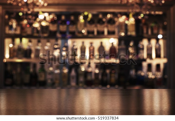 Empty wooden bar counter with\
defocused background of restaurant, bar or cafeteria and copy\
space