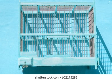 Empty Wooden Birdcage Hanging On Blue  Wall 