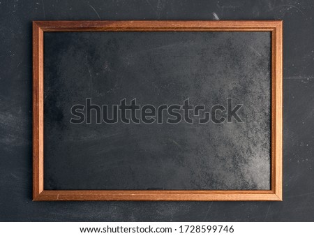 empty wooden chalk board on a black background, place for an inscription