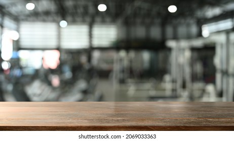 Empty Wooden Counter With Blurred Gym In Background. For Montage Your Product Display. 