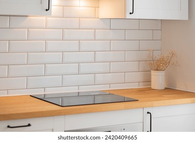 Empty wooden countertop with free space for product montage or mockup on a white kitchen with dry bouquet and brick wall in scandinavian style in morning light. Copy space. - Powered by Shutterstock