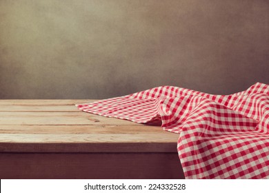 Empty wooden deck table with checked tablecloth for product montage display