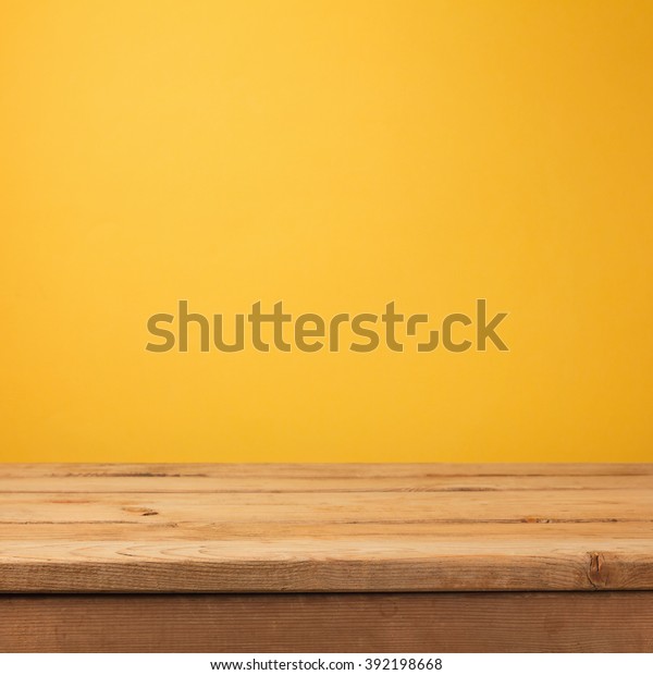 黄色い壁紙の背景に空の木のデッキテーブル の写真素材 今すぐ編集