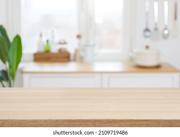 Empty wooden desk on blurred kitchen window for product presentation
