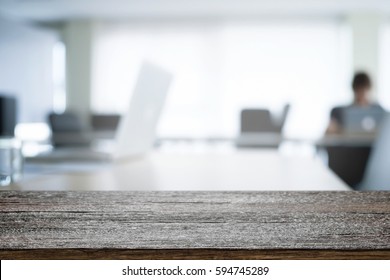 Empty wooden desk space over blurred office or meeting room background. Product display. - Shutterstock ID 594745289