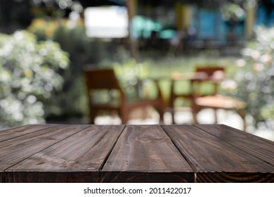Empty Wooden Desk Space Platform And Blurred Cafe Or Coffeeshop Background For Present Product.