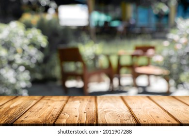 Empty Wooden Desk Space Platform And Blurred Cafe Or Coffeeshop Background For Present Product.