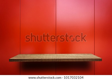 Empty wooden display shelf on Shiney red metal plate