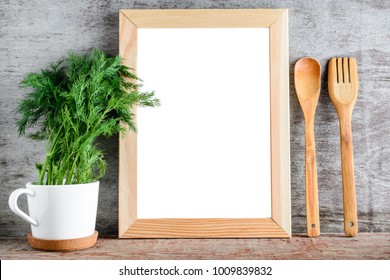 An Empty Wooden Frame And Kitchen Accessories On A Gray Wall. Layout For Design