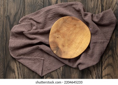 Empty Wooden Irregular Plate On Wooden Oak Kitchen Table, Top View, Flat Lay. Food Background With Copy Space