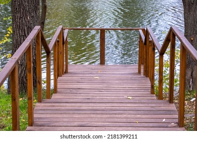 Empty Wooden Pier In A City Park On A Pound Background At Autumn Day, No People.