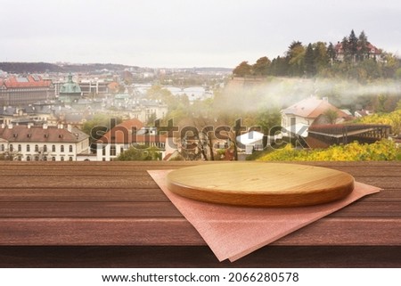 Empty wooden plate on the table with city of Czecho-Slovakia soft blurry background, of free space for your copy and branding. Use as products display montage. Vintage style concept.