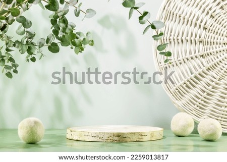 Empty wooden podium with laundry balls on blue background with eucalyptus leaves. Natural display for presentation. Eco friendly showcase for new home cleaning or laundry products and promotion sale
