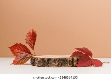 Empty wooden product podium with autumn leaves on brown and white background. Podium for design, cosmetic and product, presentation, fall concept