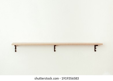 Empty wooden shelf on white cement wall background, product display montage - Powered by Shutterstock