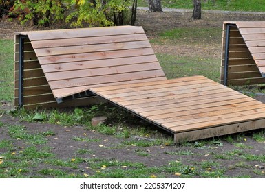 An Empty Wooden Sunbed In An Amusement Park On An Autumn Day