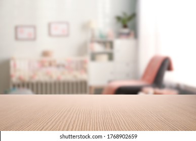 Empty wooden table in baby room interior
