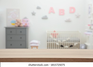 Empty wooden table in baby room. Space for text