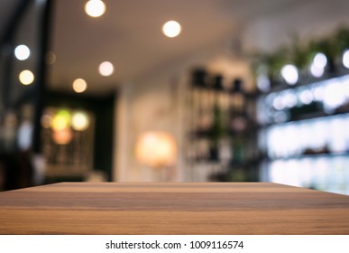 Leerer Holztisch und unscharfer Hintergrund abstrakter Bilder vor dem Restaurant oder der Cafeteria zur Produktpräsentation oder Montage.