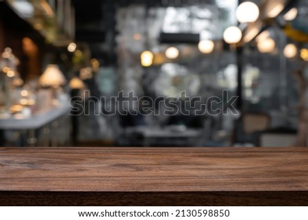 Empty wooden table with blurred background of bar and bistro.