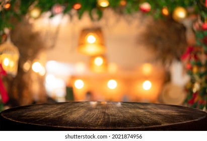 Empty wooden table and blurred Christmas background of abstract in front of coffee shop or restaurant for display of product or for montage.