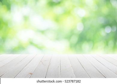 Empty wooden table with blurred city park on background