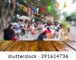 empty wooden table and blurred outdoor diner in the evening as background