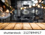Empty wooden table with blurry background of bar and bistro.