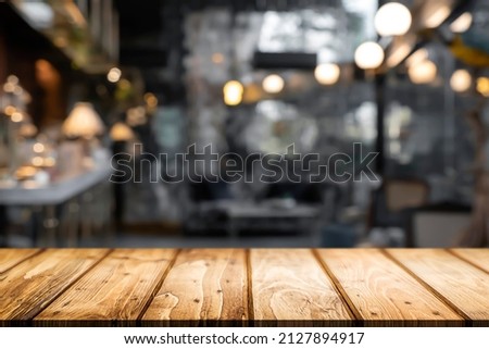 Empty wooden table with blurry background of bar and bistro.