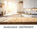 Empty wooden table with the bright white interior of the kitchen as a blurred background behind the bokeh golden sunshine . A kitchen interior, focusing on a wooden table or countertop 