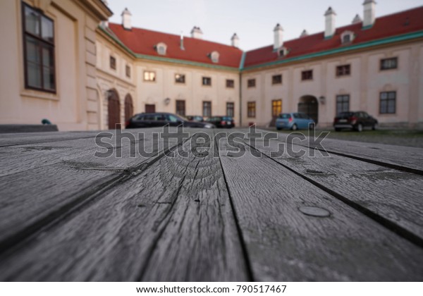 Empty wooden table with\
european house - building with parking cars on background. Wien,\
Austria.
