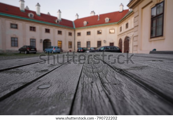 Empty wooden table with\
european house - building with parking cars on background. Wien,\
Austria.