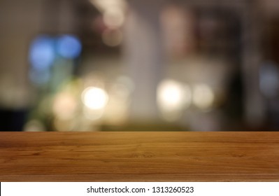 Empty wooden table in front of abstract blurred background of restaurant, cafe and coffee shop interior.  - Shutterstock ID 1313260523