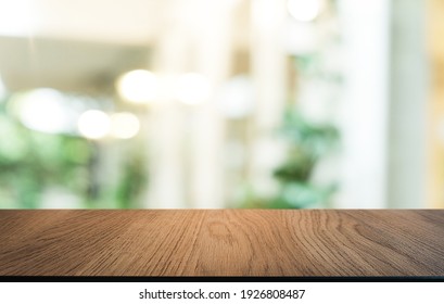 Leerer Holztisch vor abstraktem, unscharfem Hintergrund des Kaffeehauses . Der Holztisch vor der Tür kann zur Anzeige oder Montage Ihrer Produkte verwendet werden.Mock up for display of product