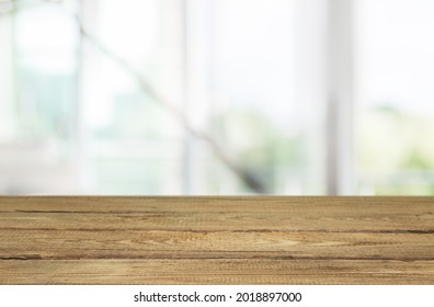 Empty wooden table in front of abstract blurred background of a room - Shutterstock ID 2018897000