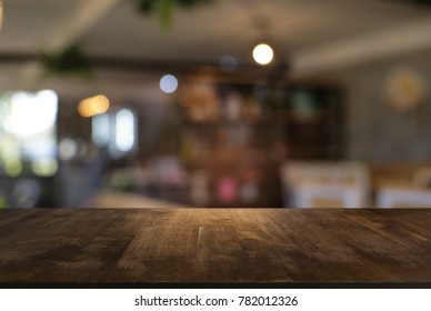 Leerer Holztisch vor abstraktem, unscharfem Hintergrund des Kaffeehauses . kann zur Anzeige oder Montage Ihrer Produkte verwendet werden.Mock up for display of product