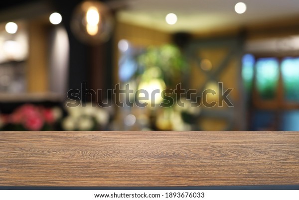 Empty wooden\
table in front of abstract blurred background of coffee shop . wood\
table in front can be used for display or montage your\
products.Mock up for display of\
product\
