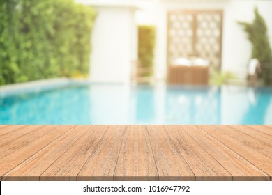 Empty Wooden Table In Front With Blurred Background Of Swimming Pool 