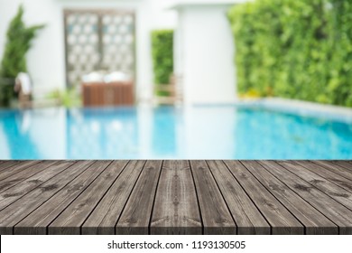 Empty Wooden Table In Front With Blurred Background Of Swimming Pool 