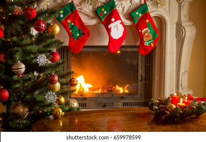 Empty wooden table in front of decorated fireplace and Christmas tree. Place for text. 