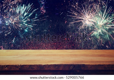 Empty wooden table in front of fireworks background. Product display montage