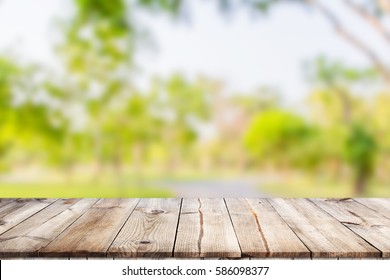 Empty Wooden Table With Garden Bokeh For A Catering Or Food Background With A Country Outdoor Theme / Template Mock Up For Display Of Product