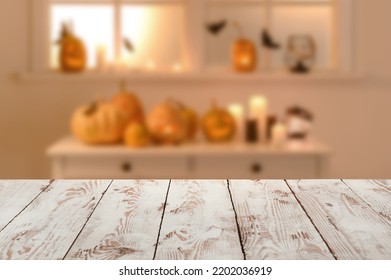 Empty wooden table in living room decorated for Halloween
