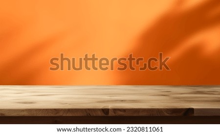 Empty wooden table on abstract orange background for product presentation, copy space
