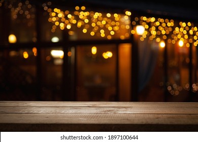 Empty Wooden Table On Blurred Light Gold Bokeh Of Cafe Restaurant On Dark Background, Place For Your Products On The Table